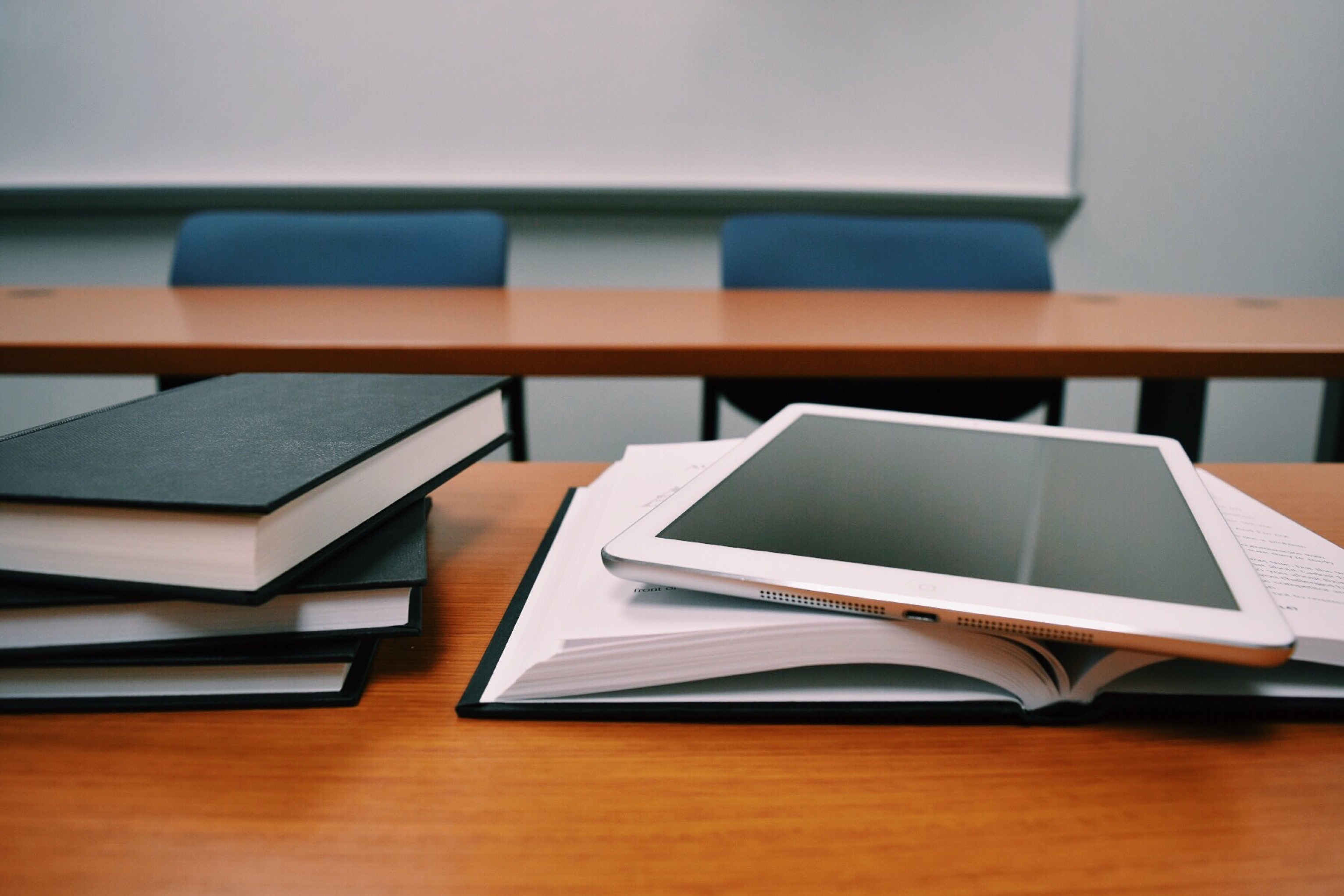 Books and a tablet on a desk.